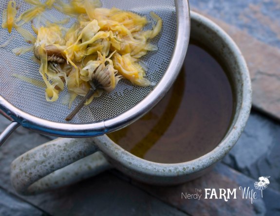 Straining Calendula Tea into a pottery cup