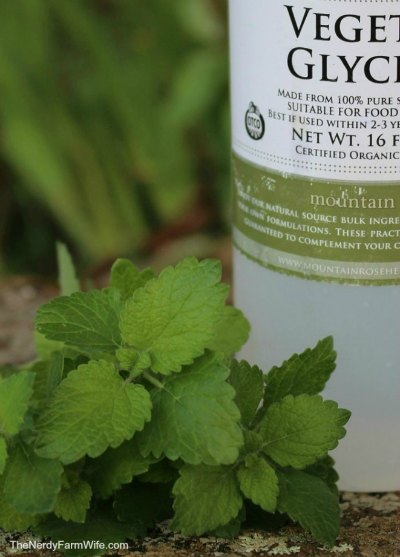 bottle of organic vegetable glycerin with fresh lemon balm leaves