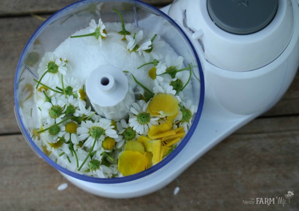 Blending chamomile flowers and Epsom salt together with a few pansy flowers for color