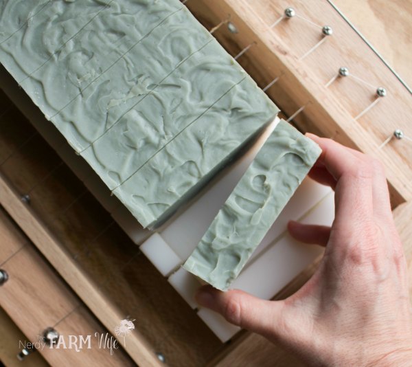 cutting handmade soap with a wooden soap cutter