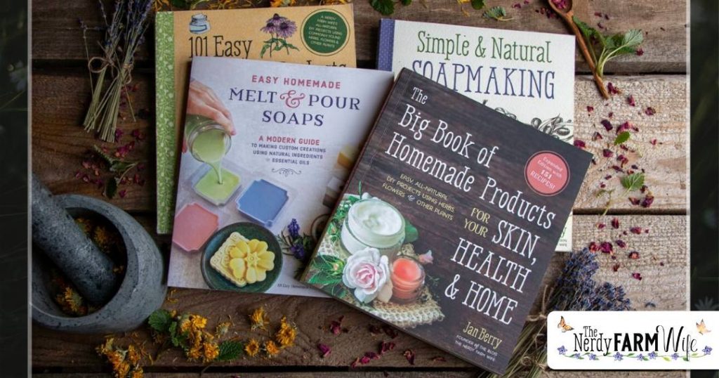 collection of several print books on a wooden background surrounded by dried flowers