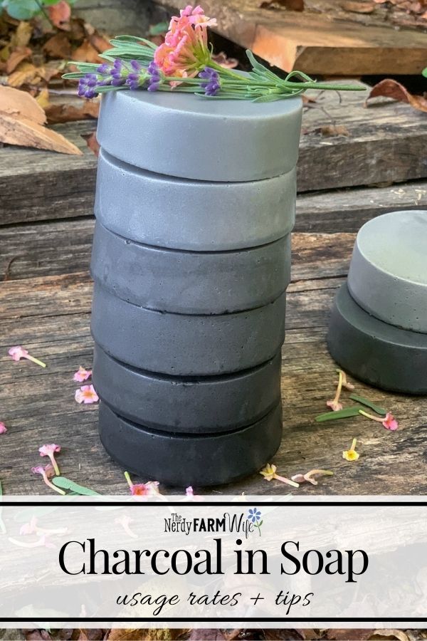 tall stack of round charcoal soaps on a wooden background, text says "Charcoal in Soap, Usage Rates & Tips"