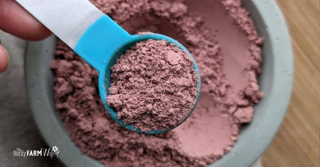 a teaspoon of pink clay over a bowl of clay