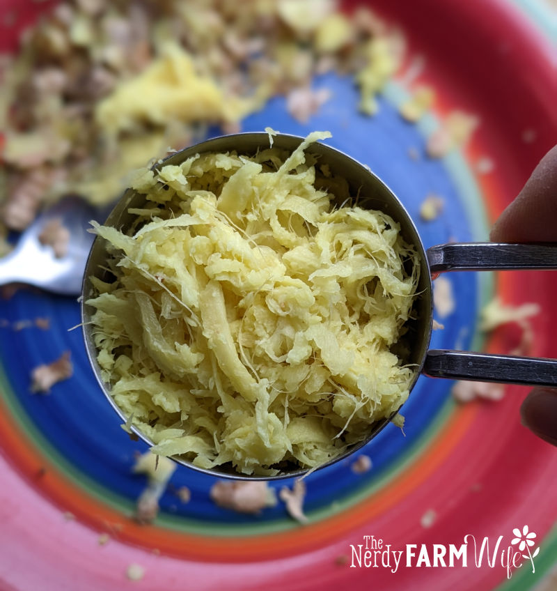 a spoon filled with grated fresh ginger