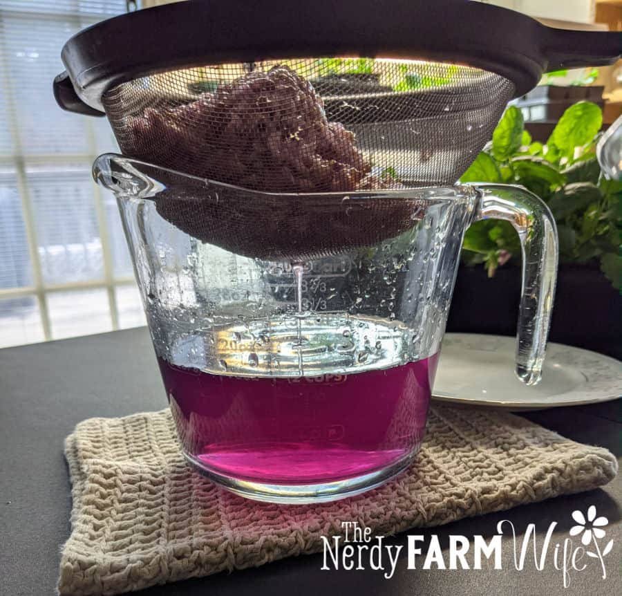 Pink redbud tea being strained
